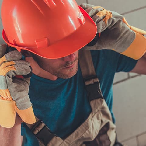 Trabajador de obra colocándose el casco de seguridad